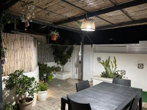 une terrasse avec une table, des chaises et des plantes en pot dans l'établissement Holiday Rooms Ninfa, à Avola