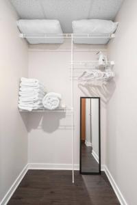 a room with a mirror and a shelf with towels at Downtown Birdseye View AC 85" TV Balcony in Traverse City