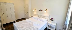Un dormitorio pequeño con una cama blanca con dos almohadas. en Villa Loebel - Exceptional Queen Louisa two bedroom apartment with 2 balconies, en Juodkrantė