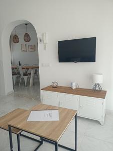 Una sala de estar con una mesa y un televisor en una pared. en Apartamento J&G Peñiscola, en Peñíscola 8 fotos más