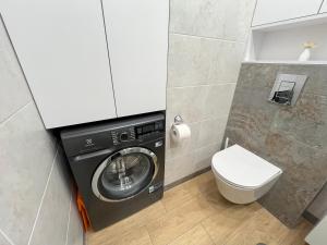 baño pequeño con lavadora y aseo en Glazurowa apartament Trójmiasto en Gdansk
