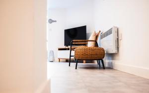 una silla y un televisor en una habitación en THE COSY APARTMENT BY KS - Free Parking, WIFI, Kitchen, Smart TV, Long stays welcomed! en Hereford