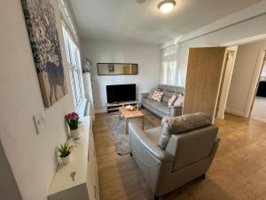 a living room with a couch and a television at Charming 4 Bed House, 20 Minutes to Central London in Edgware