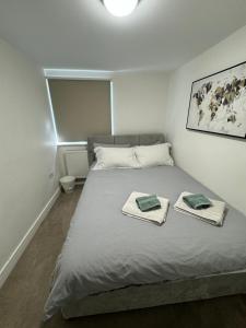 a bedroom with a bed with towels on it at Charming 4 Bed House, 20 Minutes to Central London in Edgware