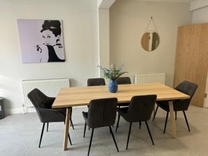 a dining room table with chairs and a vase on it at Charming 4 Bed House, 20 Minutes to Central London in Edgware