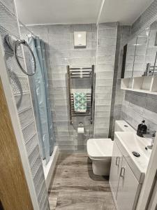 a bathroom with a toilet and a sink at Sea Walk Cottage, Milford On Sea in Milford on Sea