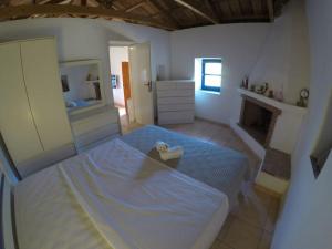 a large bedroom with a bed and a mirror at Kalamitsi House 1 in Agia Pelagia