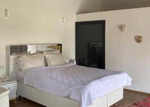 a bedroom with a large white bed with white sheets at Erdem Ciftligi/ Ephesus Arena in Selcuk