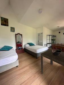 a bedroom with two beds and a mirror and a table at Paraiso de la sierra in Santa Marta