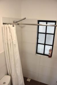 a bathroom with a white shower curtain and a window at Morada Montevideana in Montevideo