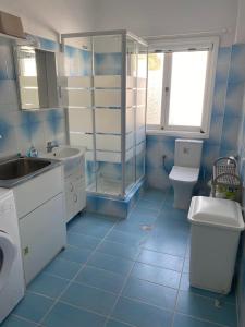 a blue and white bathroom with a sink and a toilet at Beachfront House Agia Pelagia Kythira in Agia Pelagia Kythira