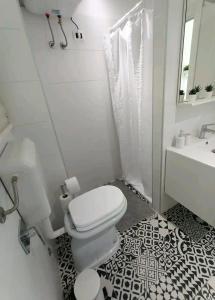 a white bathroom with a toilet and a sink at Monolocale Farina in Cagliari