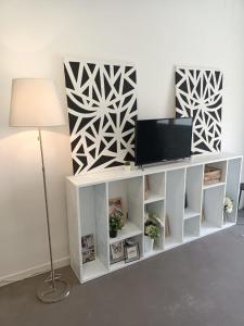 a white cabinet with a tv on top of it at Monolocale Farina in Cagliari