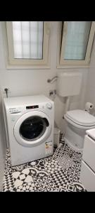 a bathroom with a toilet and a washing machine at Monolocale Farina in Cagliari