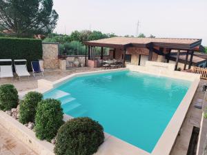 a large blue swimming pool with a gazebo at Blu Etna Casa Vacanze in Zafferana Etnea