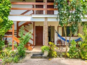 a house with a wooden door and some plants at Chez Max Pousada in Morro de São Paulo