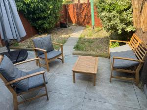 a group of chairs and a coffee table on a patio at Charming 4 Bed House, 20 Minutes to Central London in Edgware