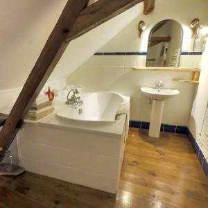 een badkamer met een wastafel en een bad bij Traditional Longère Farmhouse at La Fortinerie in Mouliherne