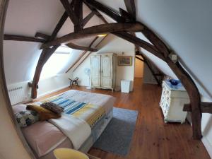 een slaapkamer met een groot bed en een spiegel bij Traditional Longère Farmhouse at La Fortinerie in Mouliherne