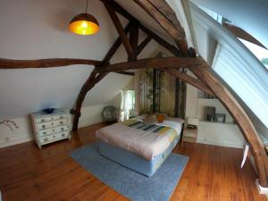 een slaapkamer met een bed op zolder bij Traditional Longère Farmhouse at La Fortinerie in Mouliherne