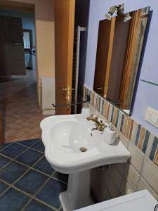 een badkamer met een witte wastafel en een spiegel bij Lo Stucchio in Monterotondo