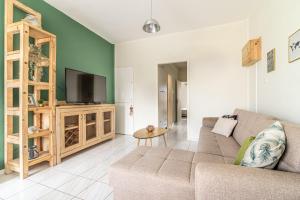 a living room with a couch and a flat screen tv at Gs house in Heraklio