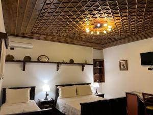 培拉特的住宿－Hotel Kaceli，一间卧室设有两张床和格子天花板