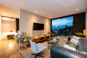 a living room with a couch and a large window at Energy Living - Ultimate Condo in Medellin in Medellín