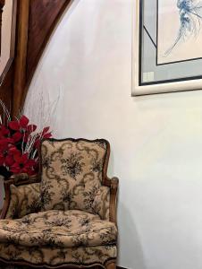 una silla sentada junto a una pared con una foto en Jardin d'Eden Family-sized Residence, 