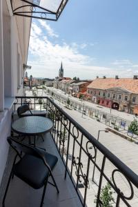 a balcony with a table and chairs and a view of a city at Salt Orchid Central in Turda