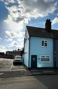 a white building with a car parked in a parking lot at Sea Walk Cottage, Milford On Sea in Milford on Sea +33 photos