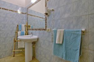 een badkamer met een wastafel, een spiegel en handdoeken bij Casa Gabriella in Fetovaia