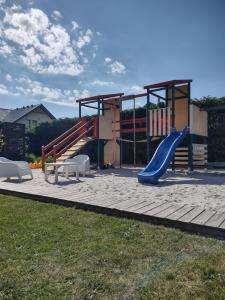 un parque infantil con un tobogán y un tobogán en Villa Cork, en Dębki