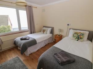 a bedroom with two beds and a window at Murmur y Mor in Goodwick