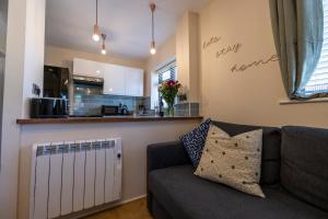 a living room with a couch and a kitchen at THE COSY HOME BY KS - Free Parking, WI-FI, Smart TV, Kitchen, Washing machine, Long Stays Welcomed in Hereford