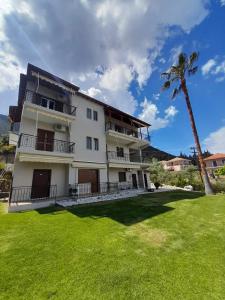 ニキアナにあるAggeliki Apartmentsの前にヤシの木がある大きな白い建物