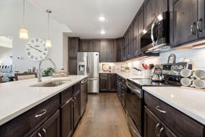 a kitchen with wooden cabinets and a stainless steel refrigerator at Serene Retreat with Hot Tub, Sauna, Pool & Gym in Windsor
