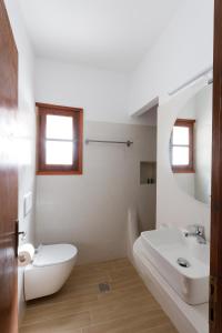 a white bathroom with a sink and a toilet at Ligaries in Kinion