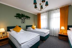 a bedroom with two beds with yellow pillows at Noclegi na Wspólnej 