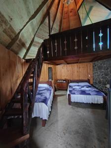 Cette chambre mansardée comprend deux lits et un escalier. dans l'établissement Hotel, Restaurante y Mirador Bosque Alegre, à Río Cuarto