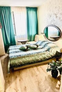 Schlafzimmer mit einem Bett und einem Spiegel an der Wand in der Unterkunft Hotel Color in Warna