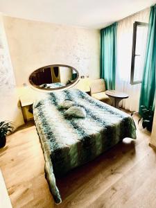 ein Schlafzimmer mit einem großen Bett und einem großen Spiegel in der Unterkunft Hotel Color in Warna