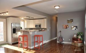 Sherwood Cottage - Steps from Old Town & Poudre River في فورت كولينز: مطبخ مع اثنين من المقاعد الحمراء في غرفة