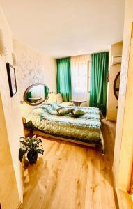 Schlafzimmer mit einem Bett und einem Wandspiegel in der Unterkunft Hotel Color in Warna