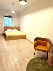 ein Schlafzimmer mit einem Bett und einem Stuhl in der Unterkunft Homey apartment central in Vilnius