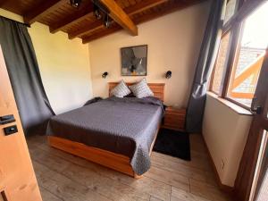 a bedroom with a bed in a room with windows at Vista Villa at Katarino SPA in Bansko