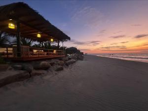 a restaurant on the beach at sunset at El Samay Hotel Boutique in Canoas De Punta Sal