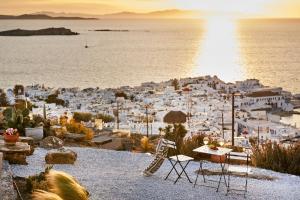 a view of a white town with the sun setting over the ocean at Sand Lily Villa Mykonos in Mýkonos City