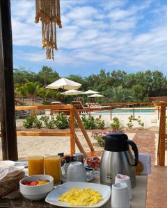 a table with breakfast food and a view of a pool at El Samay Hotel Boutique in Canoas De Punta Sal