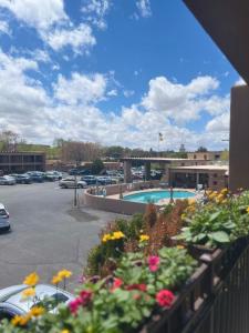 a view of a parking lot with a pool and flowers at El Sendero Inn, Ascend Hotel Collection in Santa Fe